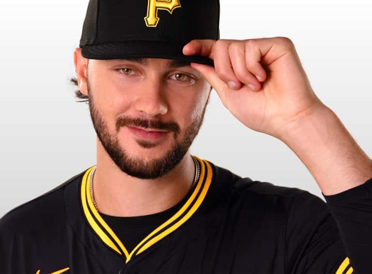 Paul Skenes tipping his Pirates cap with open space to the right for headline.