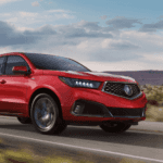 2019 Acura MDX red SUV driving on rural road
