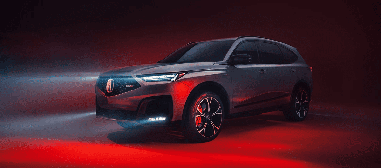 2026 Acura MDX front three-quarter studio shot with red ambient lighting