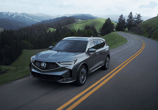 2026 Acura MDX driving on a winding mountain road