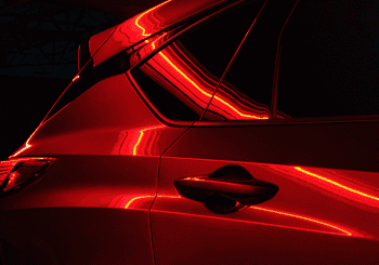 Close-up of red 2026 Acura RDX side panel with reflective lighting