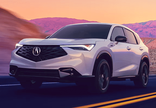 White 2026 Acura ADX A-Spec driving on a desert highway at sunset