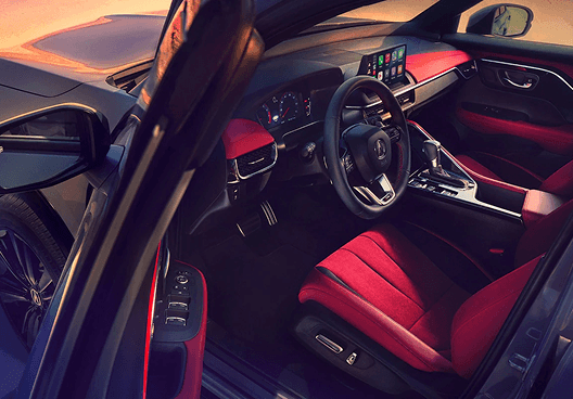 2026 Acura ADX cockpit with red seats, steering wheel, and infotainment display