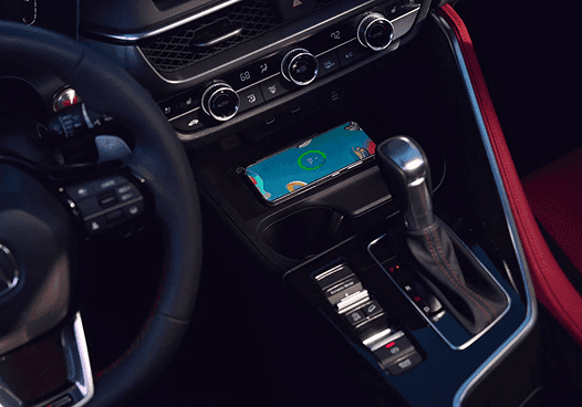 Close-up of 2026 Acura ADX center console with wireless charging pad and red ambient lighting
