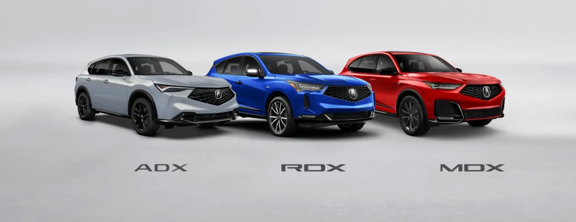 Silver Acura ADX, blue Acura RDX, and red Acura MDX SUVs parked in a row