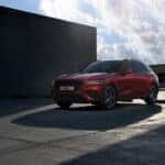 a red suv parked in front of a building