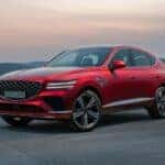 The left front view of the GV80 Coupe parked underneath a red sunset sky