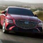 Red Genesis G80 driving on a windy road