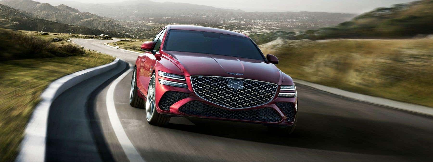 Red Genesis G80 driving on a windy road