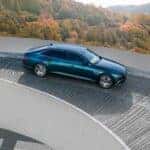 Luxury Electric Car on Curved Road in Autumn