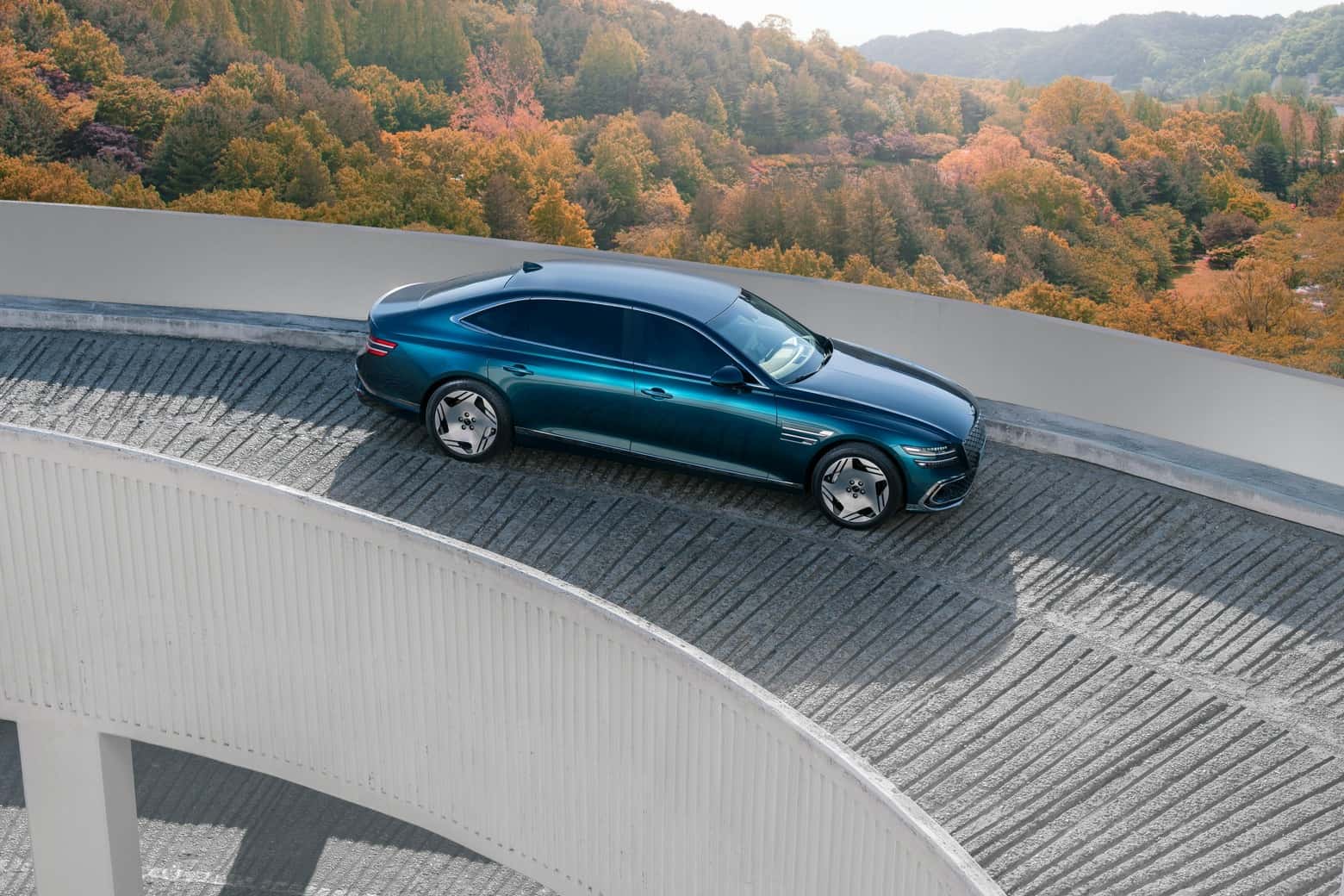 Luxury Electric Car on Curved Road in Autumn