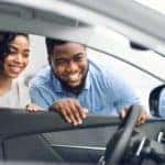 African Spouses Looking At Car Interior Buying Vehicle In Store