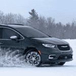 2024 Black Chrysler Pacifica driving through snow.