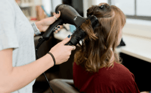Woman with brown hair sitting in a Plymouth, MA salon chair.
