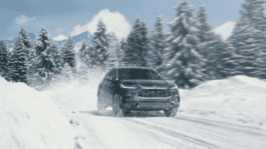 2023 honda hr-v all wheel drive in nordic forest pearl shown on a snowy road with trees behind it on a bright day