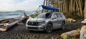 2023 honda cr-v in lunar silver metallic parked on a beach with a kayak attached to the roof