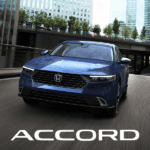 2026 Honda Accord in Canyon Blue Metallic front view driving in a city scape. accord logo at bottom in white