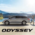 2026 Honda odyssey parked in front of a lake with mountains in the background while a man uses hands-free tailgate to get ready to load a cooler into the cargo area