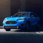 2027 Honda HR-V AWD in Boost Blue Pearl driving in a dark city scape
