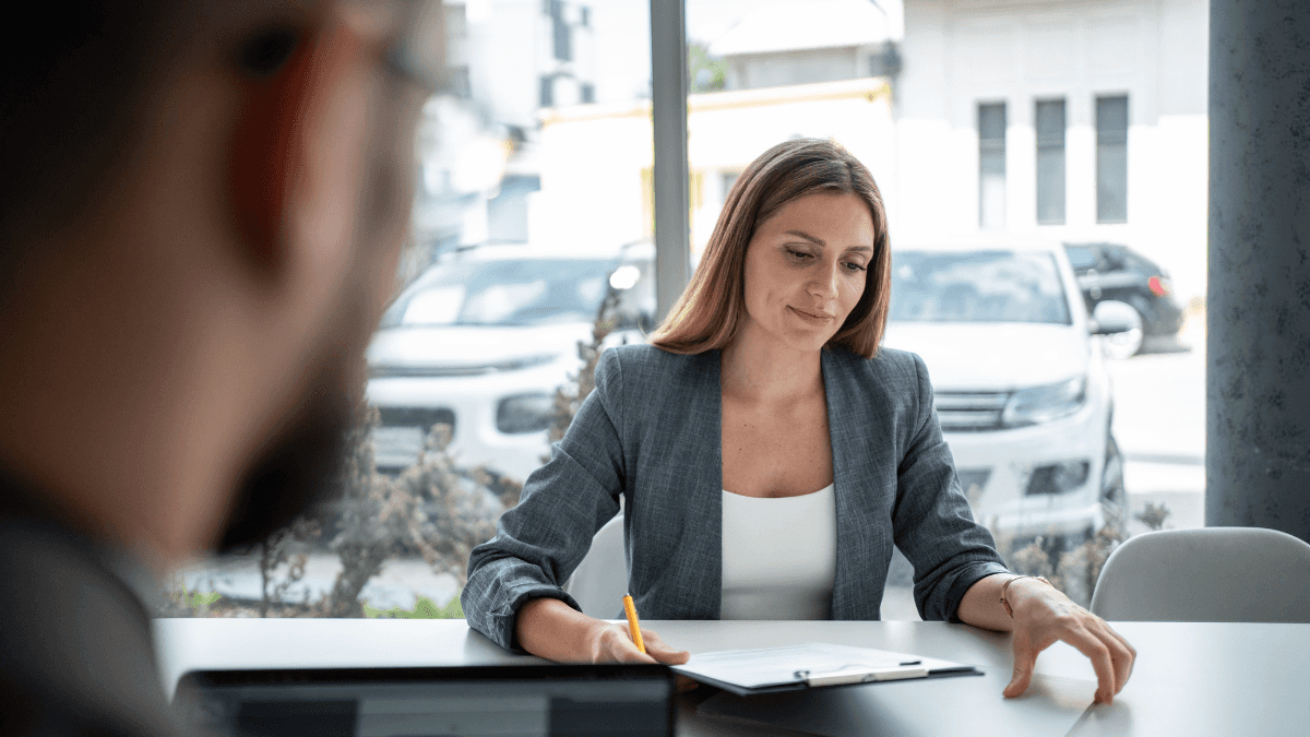 A woman looking at a financing contract at a car dealership