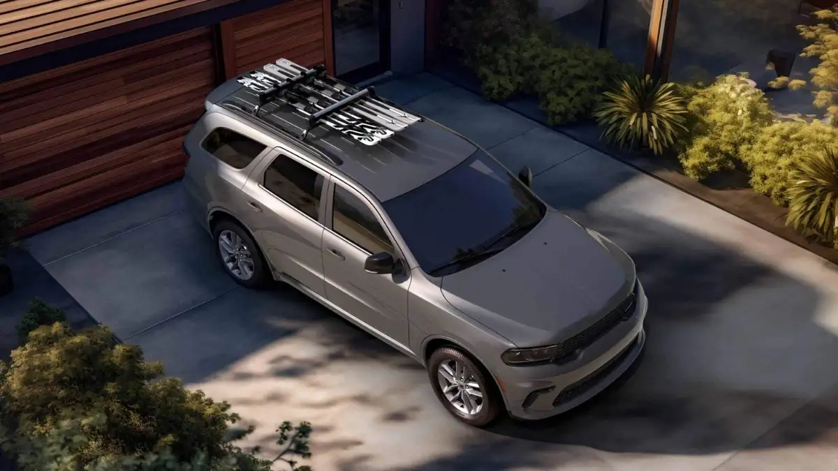 A gray Dodge Durango parked in a driveway with skis strapped to the roof