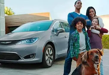 family stands in front of their minivan