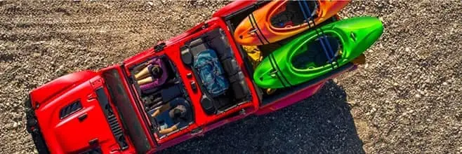 birds eye view of red jeep carrying kayaks