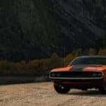 orange 1970s dodge charger on dirt road during daytime