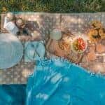 blanket with silverware, plates, and snacks for a nice picnic