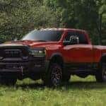 red 2023 RAM 2500 parked in a field of grass