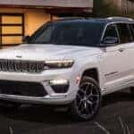 white 2024 jeep grand cherokee parked on a driveway in front of a house