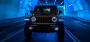 front view of a black 2024 Jeep Wrangler 4xe driving through a tunnel