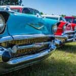 row of cars parked on grass for a car club meeting