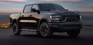 black 2024 ram 1500 parked at an angle on asphalt road.