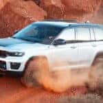 white 2024 jeep grand cherokee off roading driving in a desert