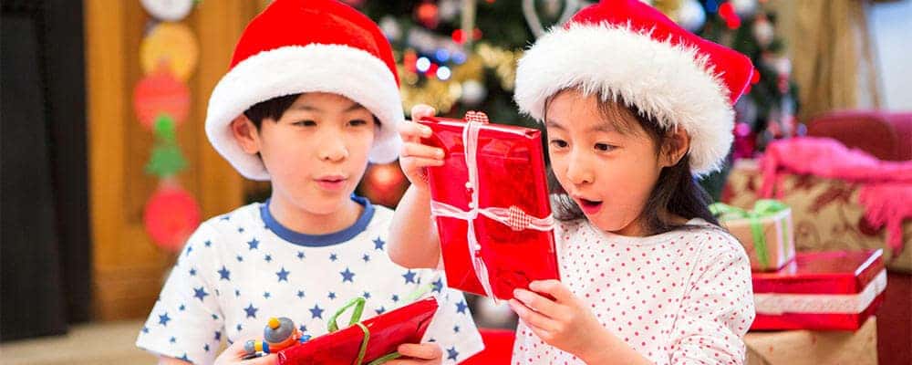 Two children in Santa hats with gifts
