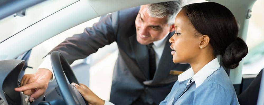Woman in new car learning about features