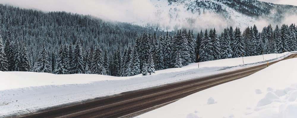 Cleared Road Surrounded by Snow During Winter