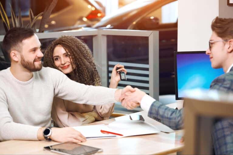 couple buying car at car dealership