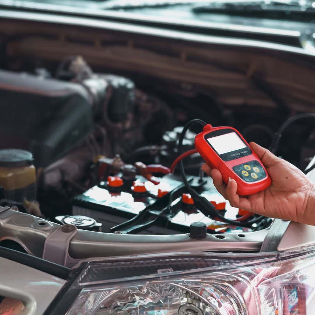 Mechanic Using Car Battery Performance Meter