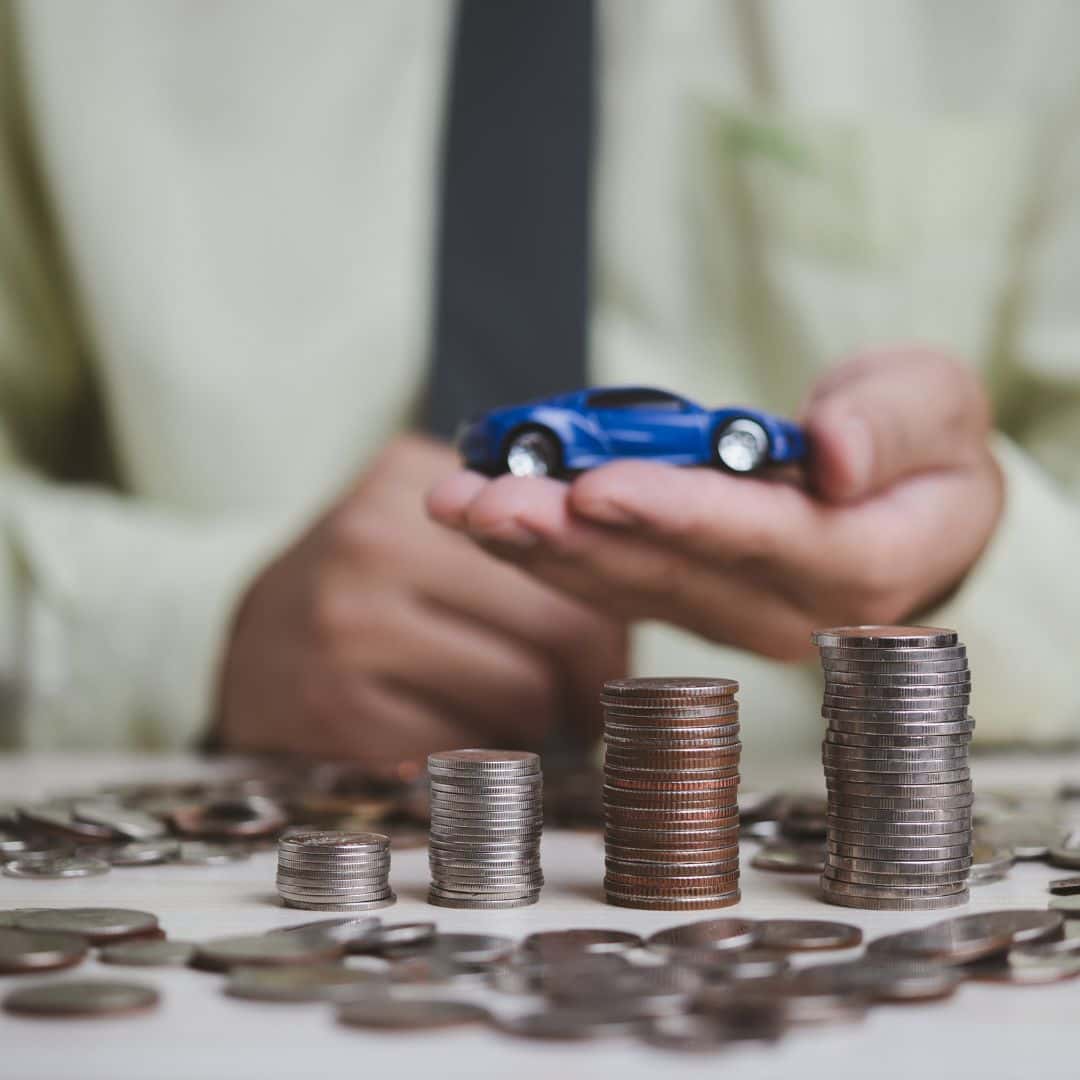 money and a toy car symbolizing the money is still owed on a car loan