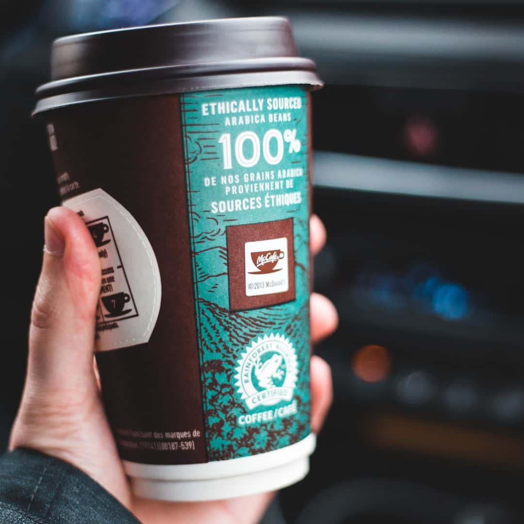 person holding a coffee in a car