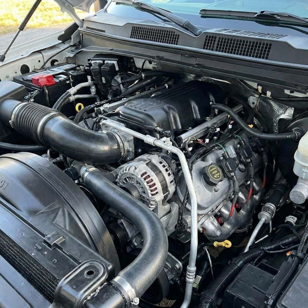 A detailed shot of a V8 engine inside the engine bay of a Chevrolet truck.