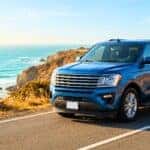 A clean Chevrolet SUV parked on a beautiful, sun-drenched road during the summer season.
