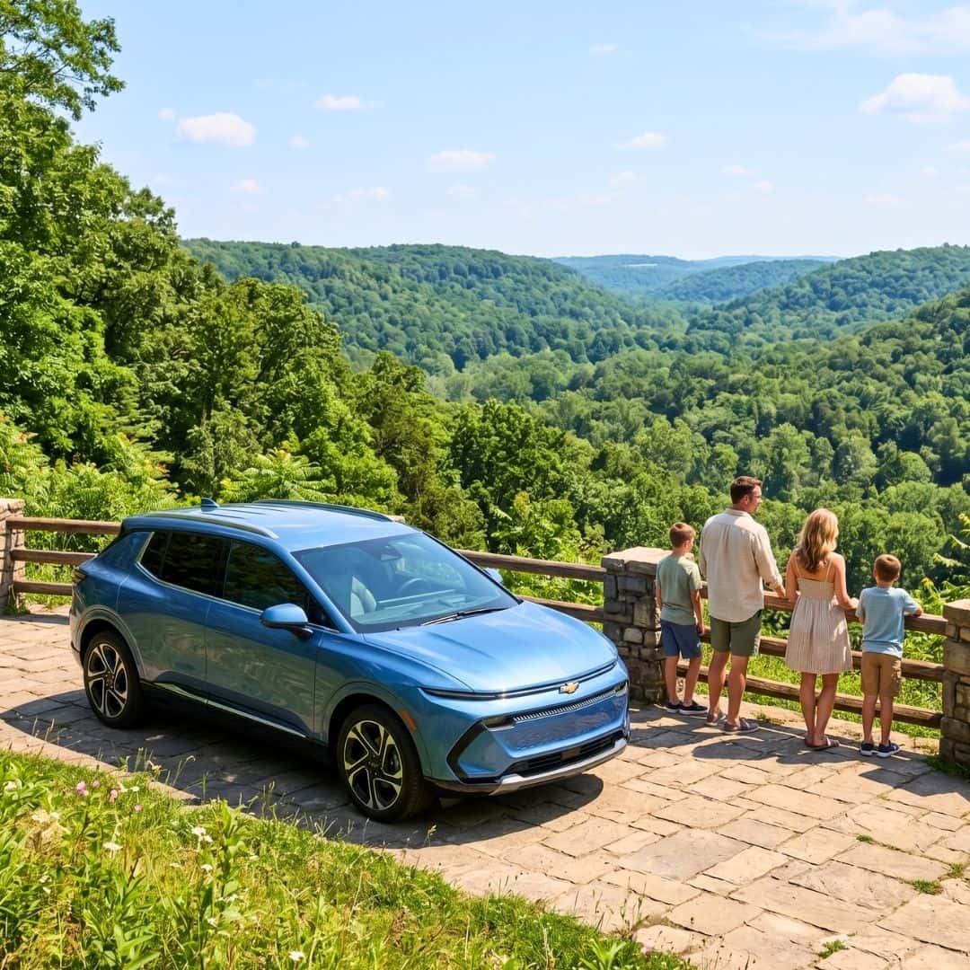 A Chevrolet Equinox EV parked at a scenic Indiana state park overlook during a sunny summer family road trip.