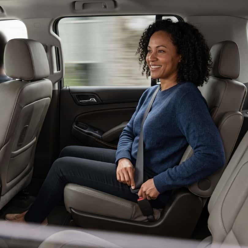 Woman buckling seatbelt in backseat of Chevy Tahoe