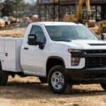 A white Chevrolet Silverado commercial service truck parked on a construction site.