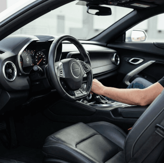 An intimate view inside a Chevrolet Camaro cockpit from the passenger perspective focuses on the ergonomic sport seats and driver interface.