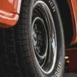 Old style rear tire on a red car.