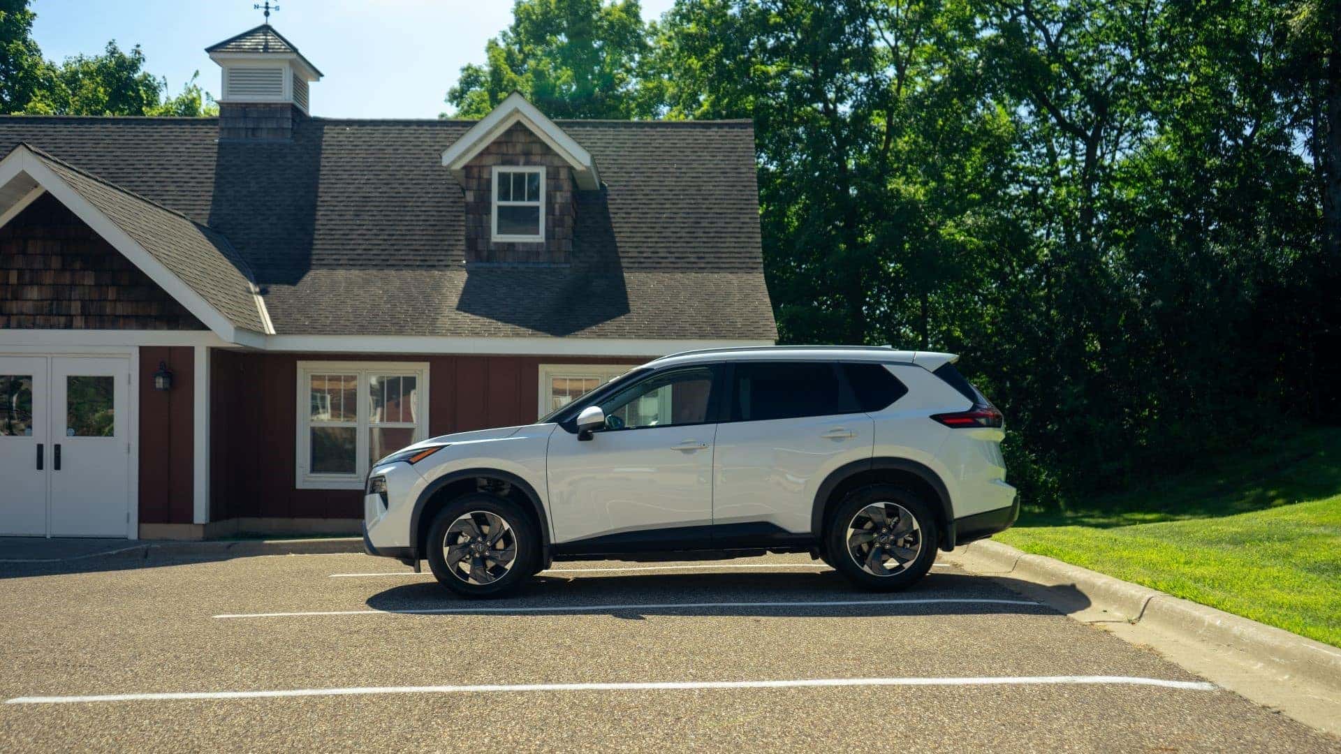 2026 Nissan Rogue driving down a country road.